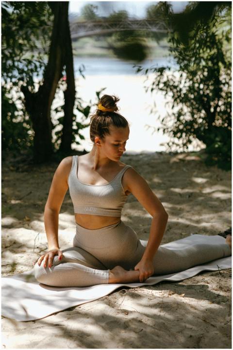 Woman performing yoga in a serene outdoor setting,