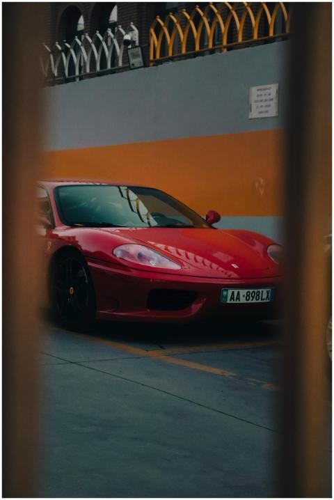 Luxurious red sports car parked in an urban enviro