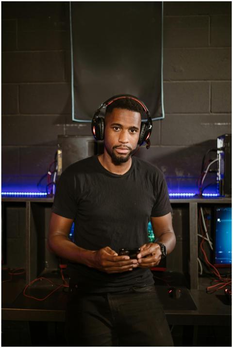 A focused gamer in a modern setup, wearing headpho