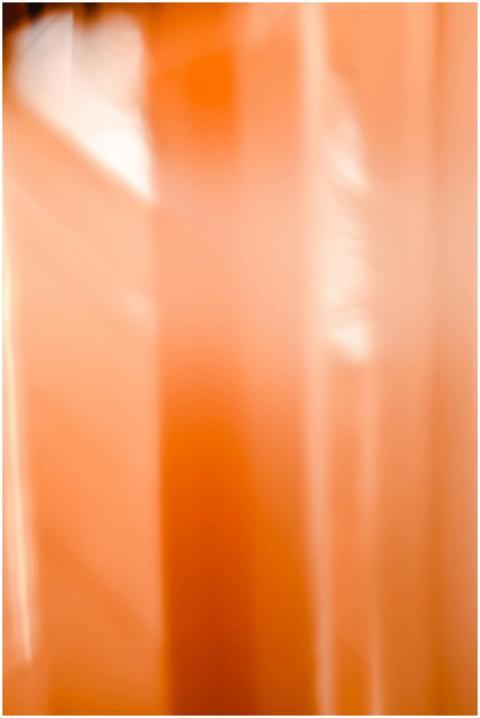 Blurry abstract image with orange light and vertic