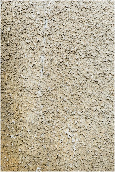 Close-up of a textured concrete wall with rough su