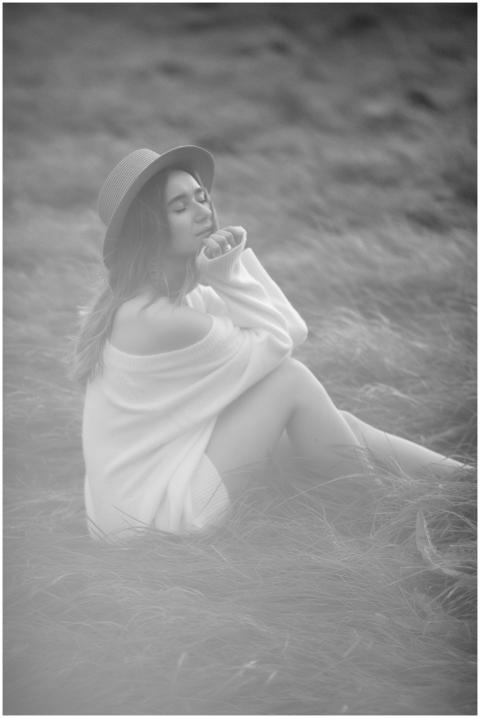 Black and white portrait of a woman in a hat sitti