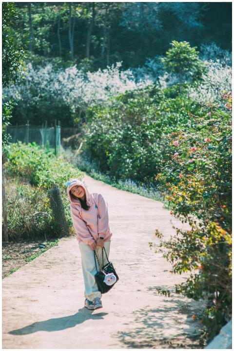 A woman in casual attire enjoys a sunny outdoor wa