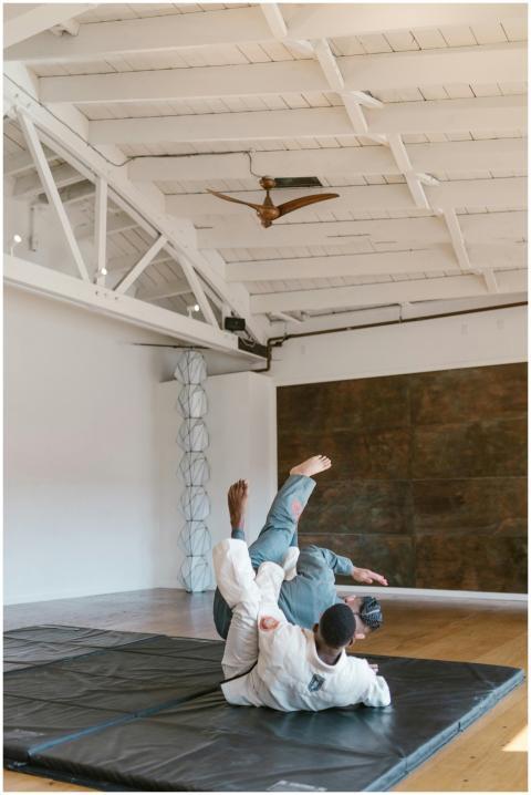 Two men practicing martial arts in a well-lit indo
