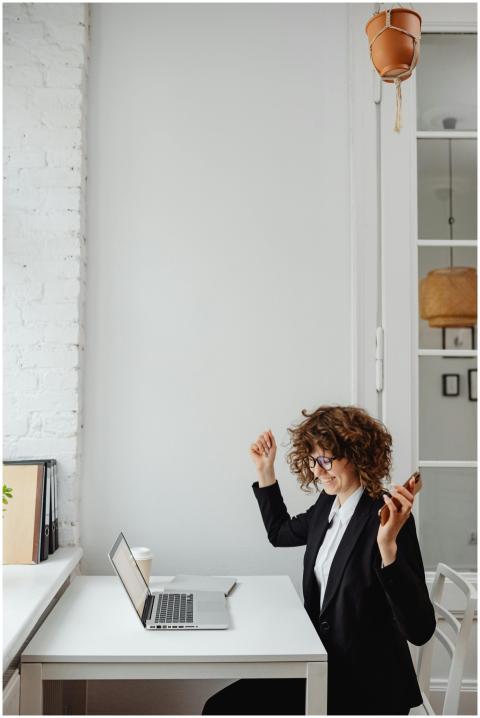 Businesswoman with curly hair celebrates success o