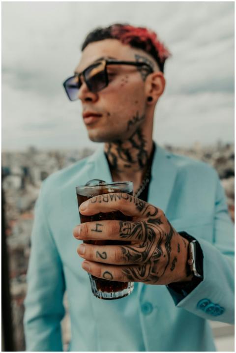 Stylish tattooed man with drink on Buenos Aires ro