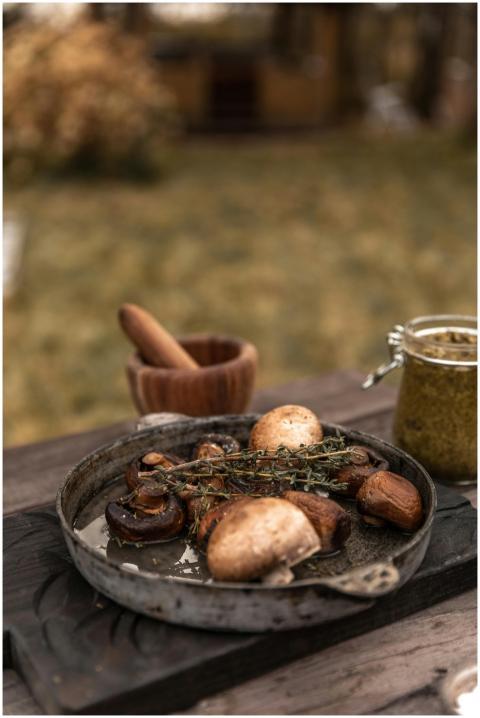 A rustic outdoor setup with gourmet mushrooms, her