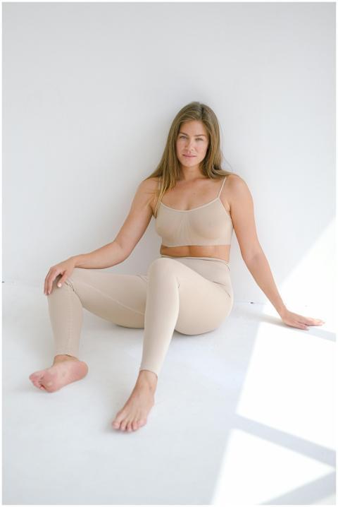 Full body of barefoot slender female wearing beige