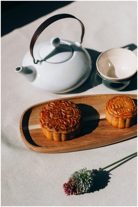 Traditional mooncakes on wooden tray with teapot a