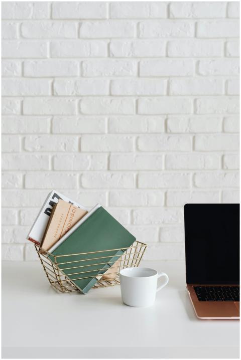 A clean and organized desk setup with a laptop, cu