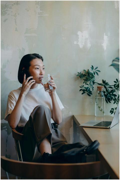 Asian woman multitasking with a phone call and dri