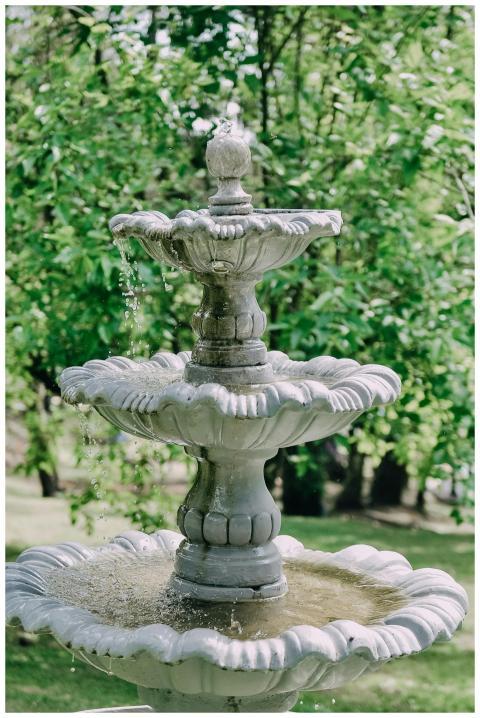 A tranquil three-tier stone fountain with flowing