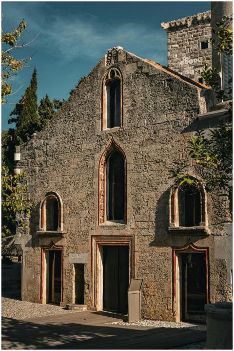 A medieval stone building with arched windows loca