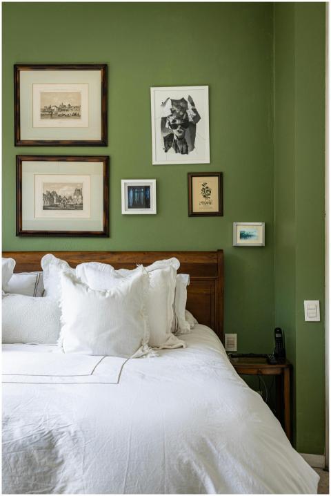 Comfortable bedroom with white bedding, green wall