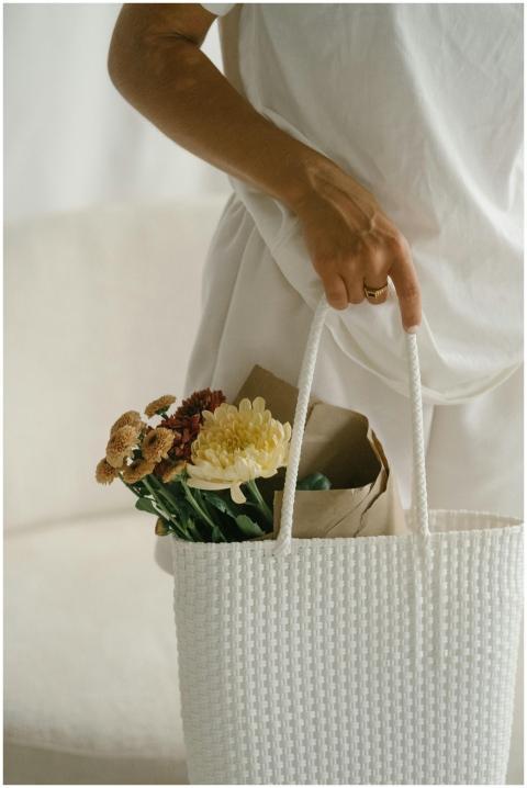 Close-up of a woman holding a white bag with fresh