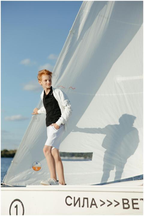 Teen boy enjoying leisure time on a sailboat, expe