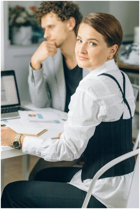 Business colleagues in discussion, using a laptop