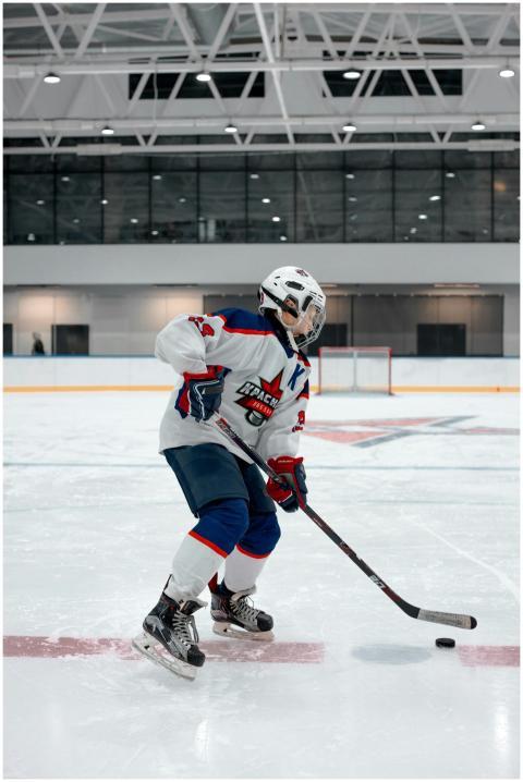 A young hockey player in full gear playing on an i