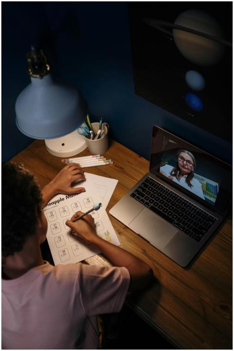 Child engaged in online learning session with a te