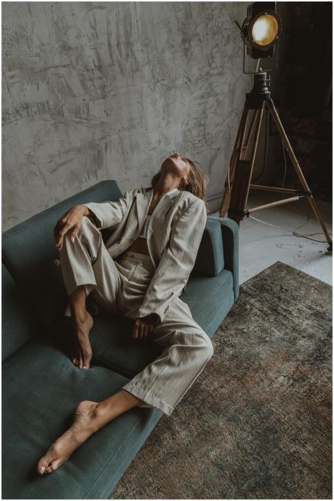 A stylish woman posing in a trendy outfit on a sof