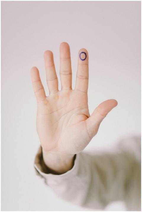 Close-up of a hand with a blue circle drawn on the