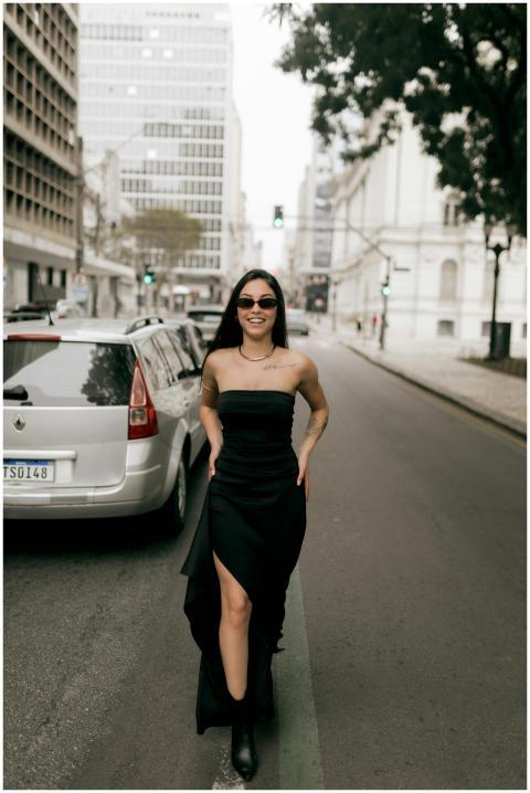Stylish woman in black dress and sunglasses walkin