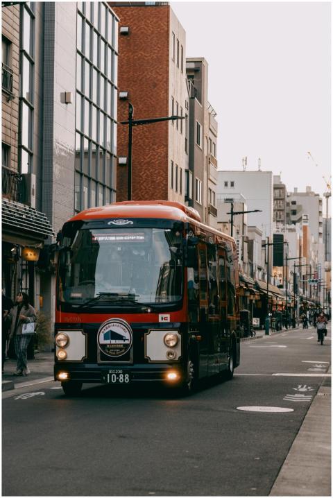 A city bus drives through a bustling street in Tok