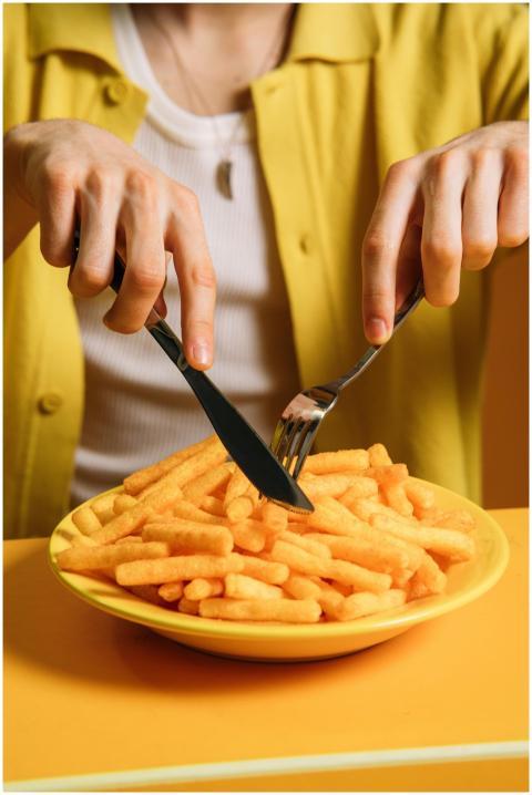 A young man enjoying a plate of crispy snacks with