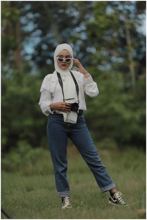 A fashionable woman wearing sunglasses and hijab,