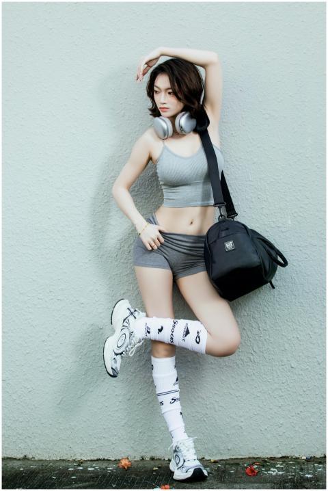 Confident woman in sporty attire posing against a