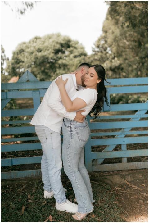 A couple shares an affectionate embrace near a blu