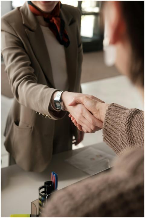 Two professionals shaking hands in an office, sign