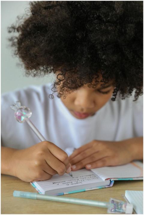 Young African American girl with afro hair writing