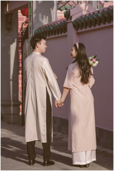 A couple in traditional clothing holding hands out