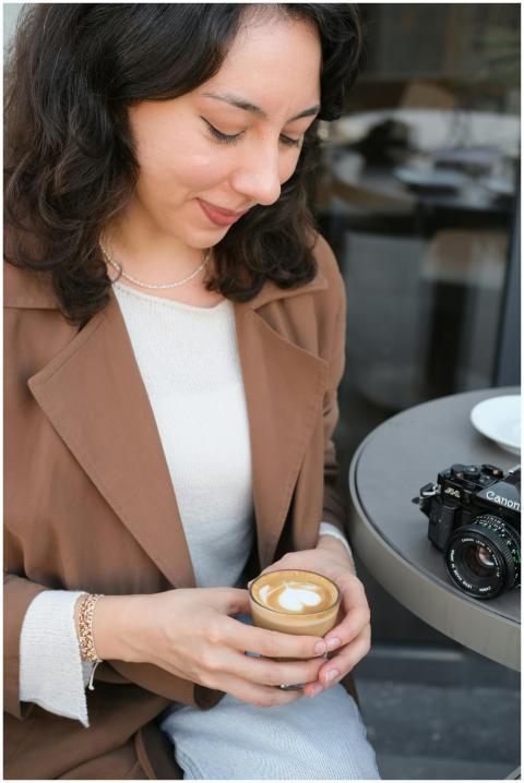 A woman savoring cappuccino at an outdoor cafe in