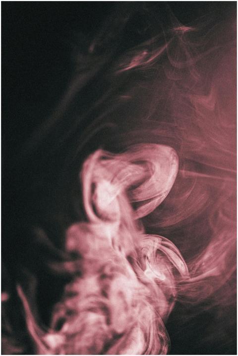Abstract pink smoke swirling on a dark background,