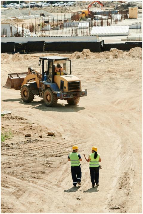 Construction workers in safety gear walking at a b