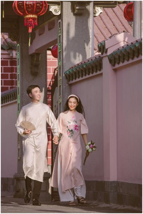 Happy couple dressed in traditional Ao Dai walking
