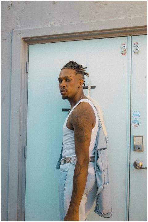 Fashionable young man with tattoos poses confident