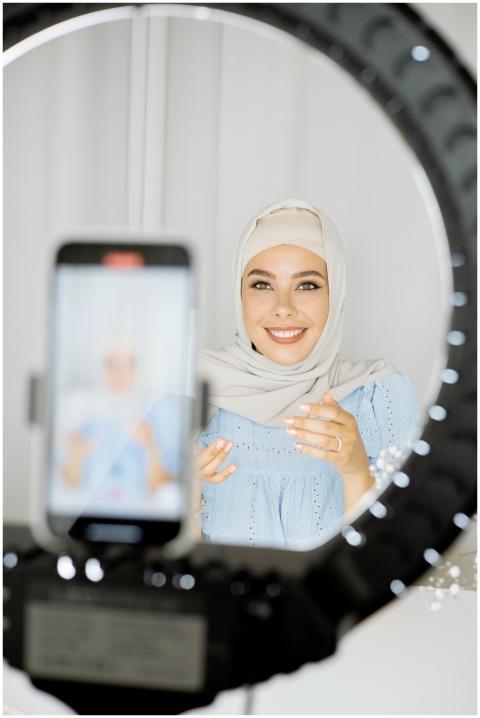 Smiling Muslim woman in hijab creating vlog conten