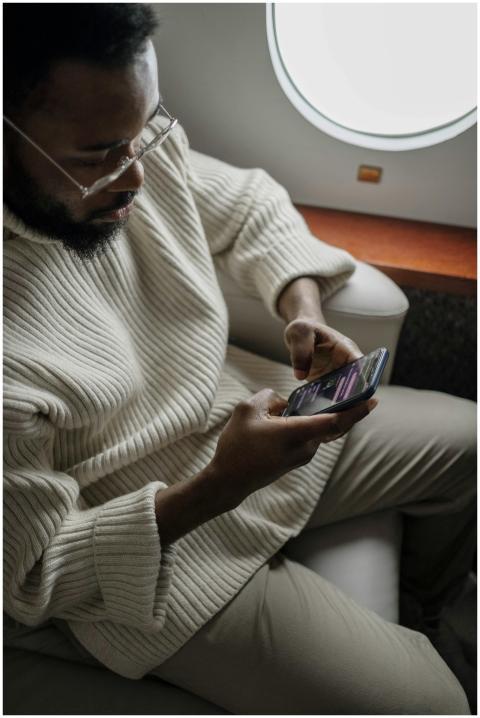 Professional man using smartphone during a flight,