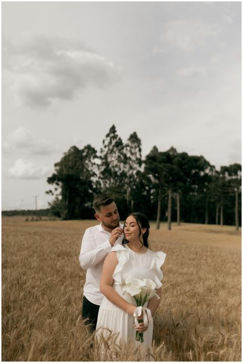 A couple shares a tender moment in a serene wheat