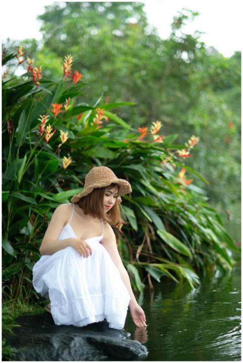 A serene portrait of a young woman in a white dres