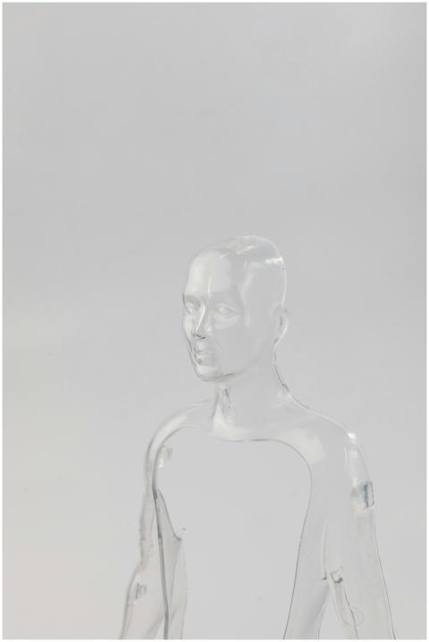 Glass-like transparent mannequin against a light b