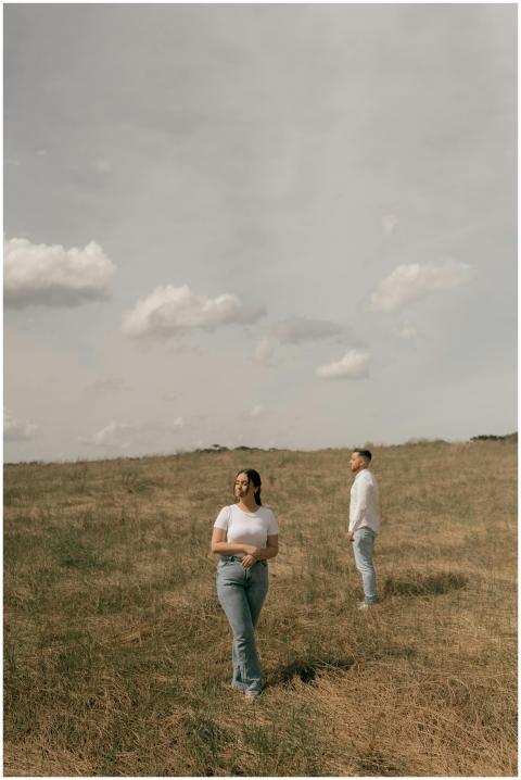 Young couple in casual attire standing in open fie