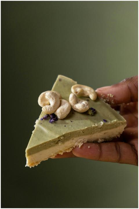 Close-up of a hand holding a slice of vegan cashew