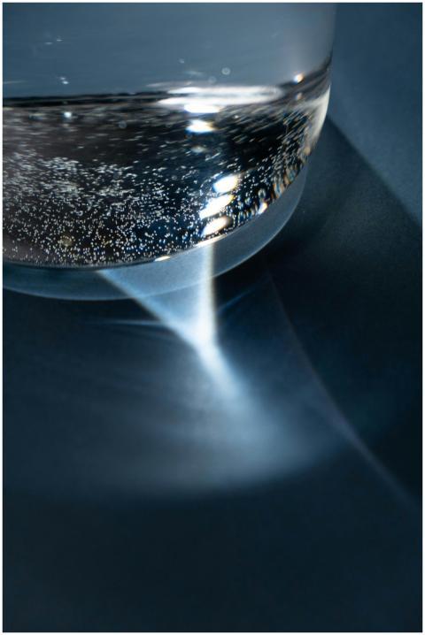 A creative close-up of a glass of water on a blue