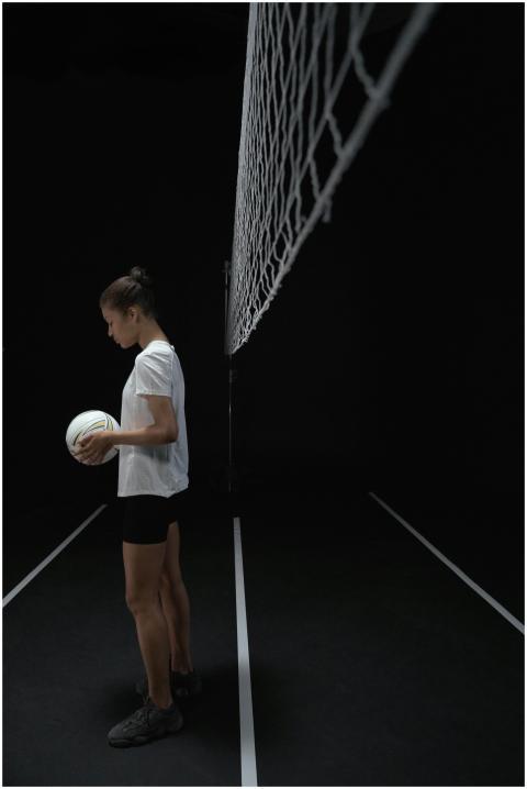 Young female athlete holding a volleyball on an in