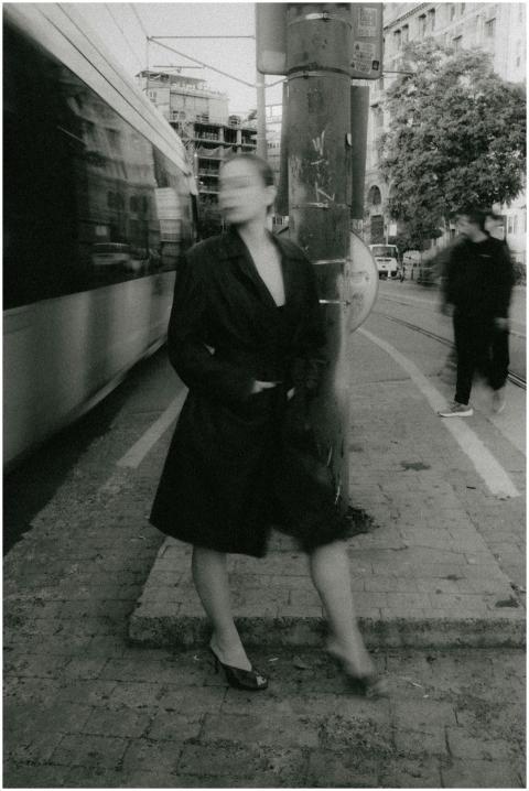 A black and white photo of a blurred woman standin
