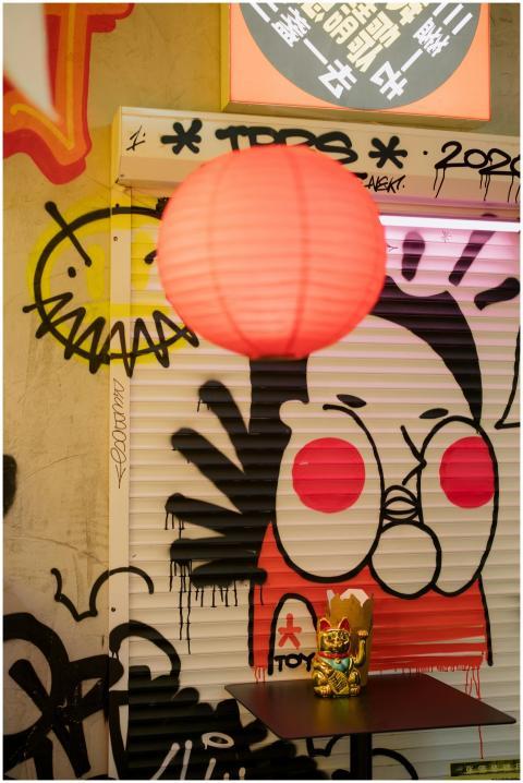 Graffiti-covered wall with Chinese lantern and Man